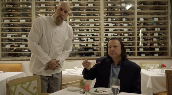 Watch Sacha Baron Cohen feed a food critic a filet of "Chinese dissident"