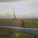 Cyclist rides along a wind turbine blade for our amusement and climate change fundraising