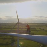 Cyclist rides along a wind turbine blade for our amusement and climate change fundraising