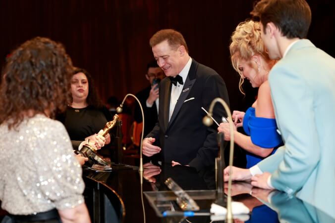 Best Actor winner Brendan Fraser getting his Oscar engraved as his family looks on