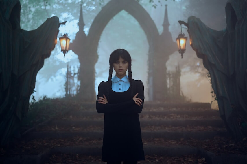 jenna ortega as wednesday addams in a spooky background with her arms crossed - wednesday season 2 first look