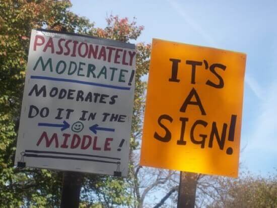One sign that says "Passionately moderate!" and "Moderates do it in the middle!" and another that says "It's a sign!"