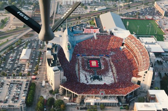 View from a jet flying over Memorial Stadium in Nebraska with 92,000 fans watching a women's volleyball game below