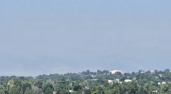 A smoke-filled sky blocking out a view of multiple mountains